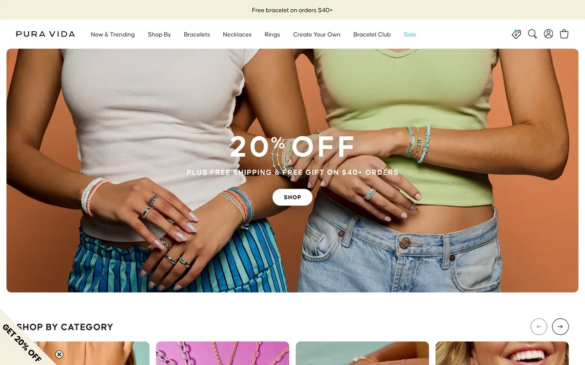 The Pura Vida homepage on desktop, showing a promotional top bar, a header carrying New and Trending, Shop By, Bracelets, Necklaces, Rings, Create Your Own, Bracelet Club and Sale, above a hero image.
