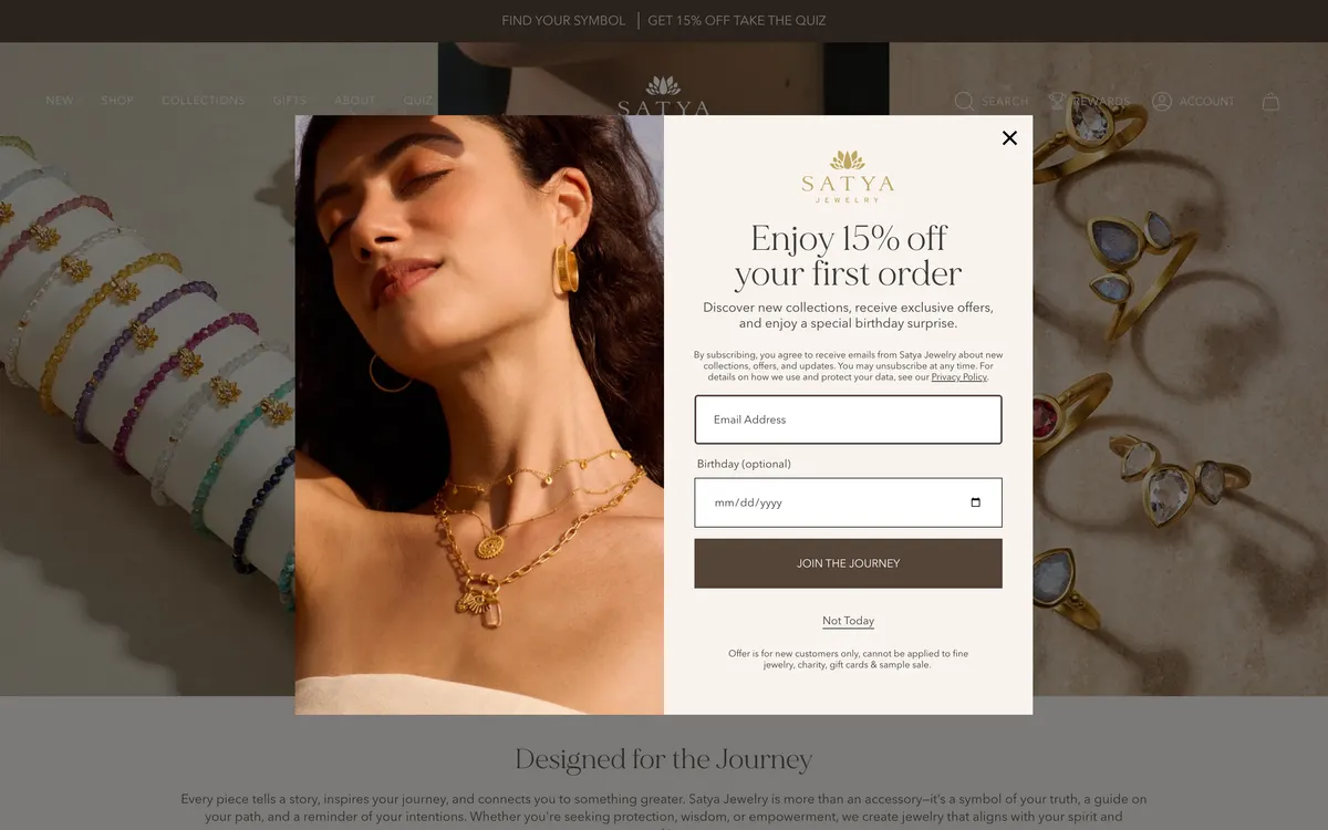 The Satya Jewelry homepage on desktop, showing a dark top bar reading Find Your Symbol, Get 15% Off, Take The Quiz, a header with New, Shop, Collections, Gifts, About and Quiz on the left and Search, Rewards, Account and cart on the right, and a first-order newsletter popup open over the hero.
